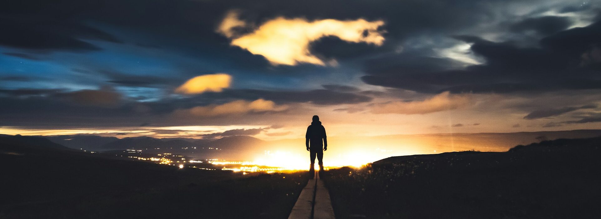 Silhouette eines Wanderers vor n&auml;chtlicher Skyline